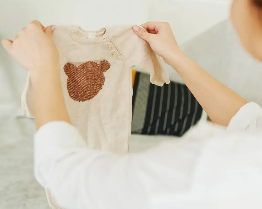 Una madre mirando si la ropa del bebé todavía le entra